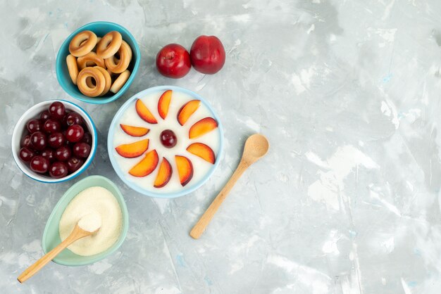 Dessert di vista superiore con i frutti affettati frutta dentro il piatto con la frutta fresca dei cracker dolci su bianco