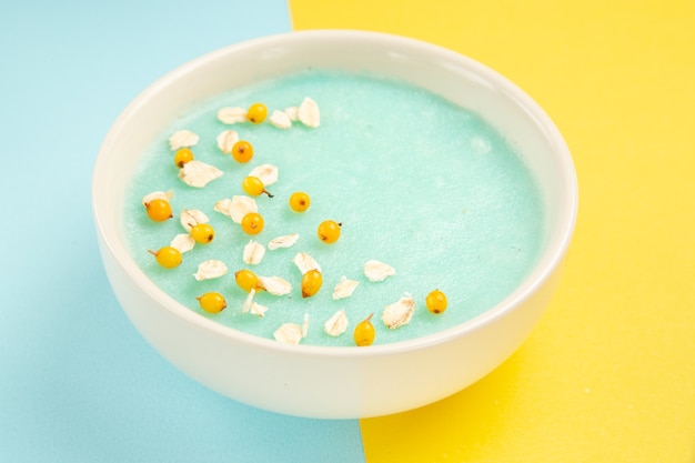 Dessert ghiacciato blu di vista frontale all'interno del piatto sul cereale di colori del latte blu-giallo della tavola