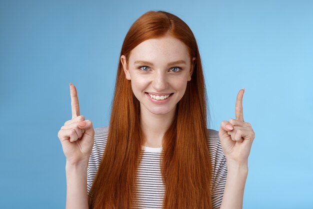 Determinata studentessa dai capelli rossi di bell'aspetto entra nella decisione finale del college puntando verso l'alto l'indice alzato con sicurezza i denti bianchi sorridenti guardano la telecamera assertiva dando raccomandazione su cosa scegliere.