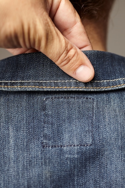 Dettagli del modello che indossa una giacca di jeans blu