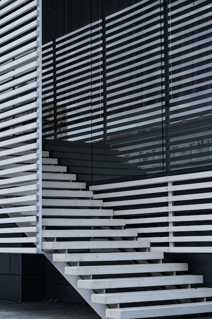 Dettagli della ringhiera e delle scale di un edificio moderno e riflesso dell'ombra sulle finestre