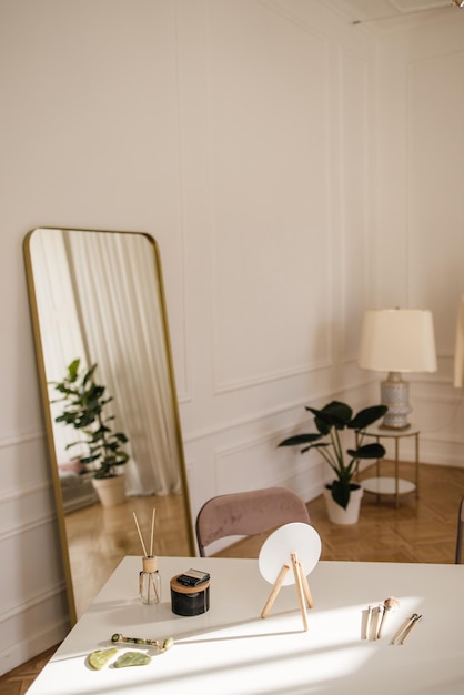 Dettagli di decorazione nel moderno salone di bellezza, tavolo, specchio, vaso di fiori, lampada. Concetto di arredamento elegante