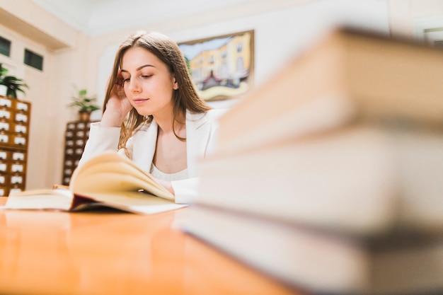 Di nuovo al concetto della scuola con la donna che studia nella biblioteca