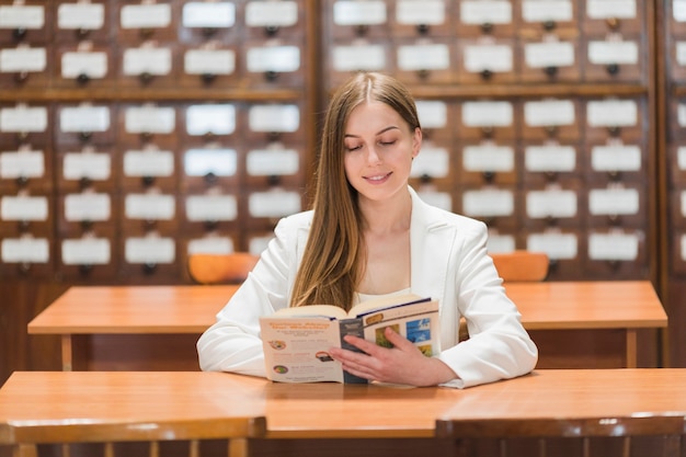 Di nuovo al concetto della scuola con la donna che studia nella biblioteca