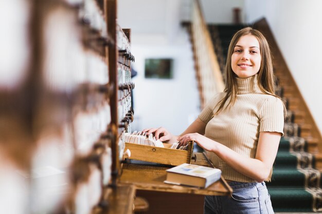 Di nuovo al concetto della scuola con la donna che studia nella biblioteca