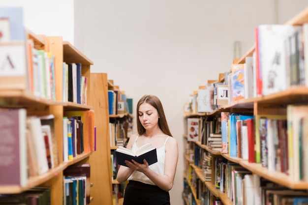 Di nuovo al concetto della scuola con la donna che studia nella biblioteca