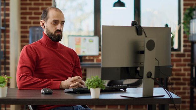 Dipendente dell'azienda che parla con persone in videoconferenza online, utilizzando la webcam sul computer per partecipare a una riunione di lavoro. Giovane in chat in videoconferenza per discussione a distanza.