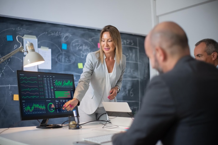 Foto gratuito dipendenti dell'azienda che discutono dei dati di mercato sui grafici. leader donna esperta e due uomini che guardano i diagrammi sullo schermo del computer che analizzano la crescita dei profitti. crescita aziendale e concetto di leader aziendali femminili