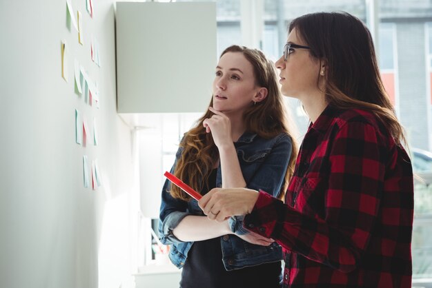 Dirigenti aziendali che discutono sopra le note appiccicose