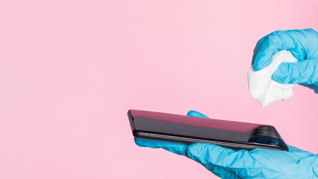 Disinfezione dello smartphone con guanti chirurgici