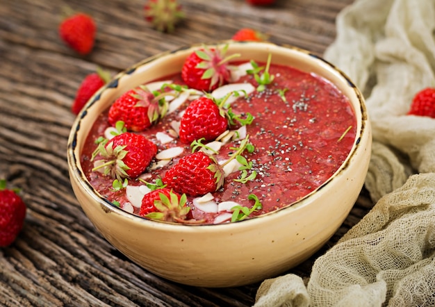 Disintossicante e salutare supercibi colazione in una ciotola. Budino di semi di chia vegano con fragole e mandorle. Frullato Di Fragole.