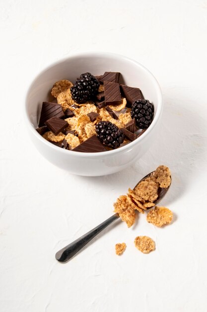 Disposizione ad alto angolo di cereali sani ciotola con cioccolato