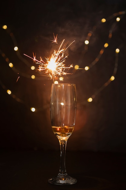 Disposizione con bicchiere di champagne e fuochi d'artificio