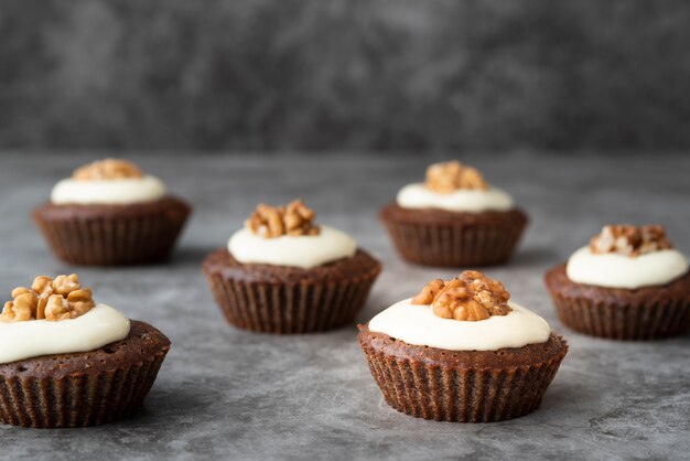 Disposizione con deliziosi cupcakes e stucchi sullo sfondo