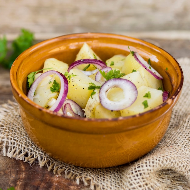 Disposizione con insalata di patate in una ciotola