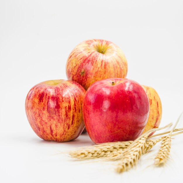 Disposizione con mele rosse e spighe di grano