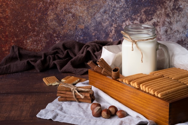 Disposizione con vasetto di latte e biscotti