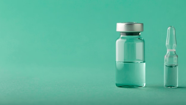 Disposizione della bottiglia del vaccino sul verde