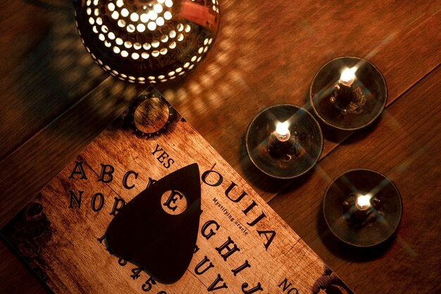 Disposizione della tavola Ouija e delle candele piatta
