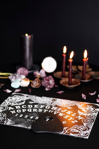 Disposizione delle candele e della vecchia tavola di Ouija ad alto angolo