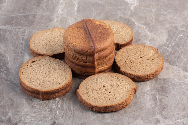 Disposizione delle fette di pane nero su fondo marmo. Foto di alta qualità