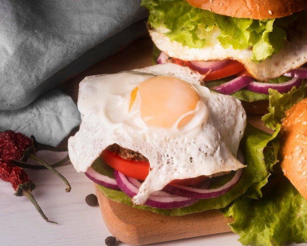 Disposizione di deliziosi hamburger con uovo fritto