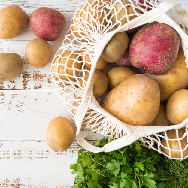 Disposizione di diverse patate crude in sacchetto