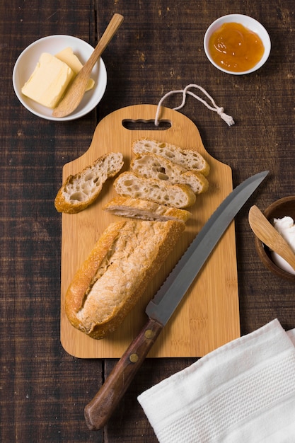 Disposizione di pane e ingredienti su tavola di legno