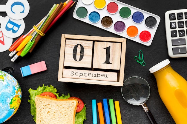 Disposizione piana degli elementi essenziali della scuola con sandwich e calendario