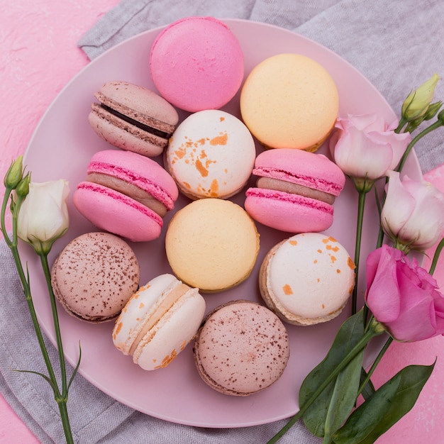 Disposizione piana dei macarons sul piatto con le rose