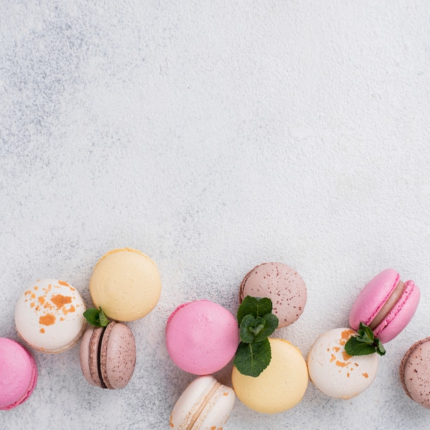 Disposizione piana dell'assortimento di macarons con lo spazio della copia e la menta