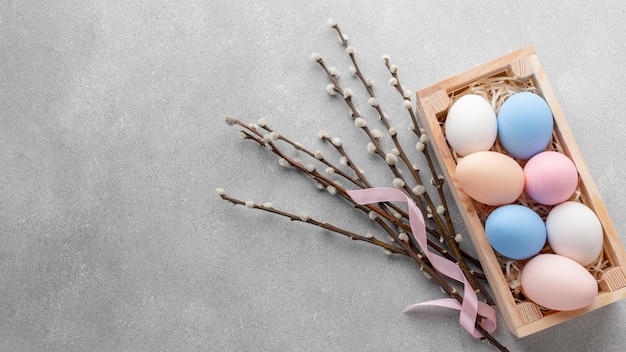 Disposizione piana della scatola con le uova di Pasqua variopinte e lo spazio della copia