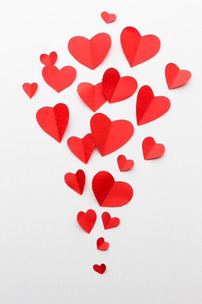 Disposizione piana delle forme del cuore di carta per il giorno di biglietti di S. Valentino