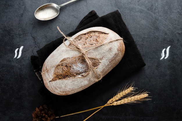 Disposizione piana di pane e di grano su fondo nero