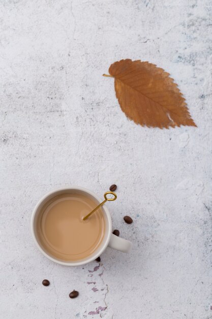 Disposizione piatta con tazza di caffè e foglia