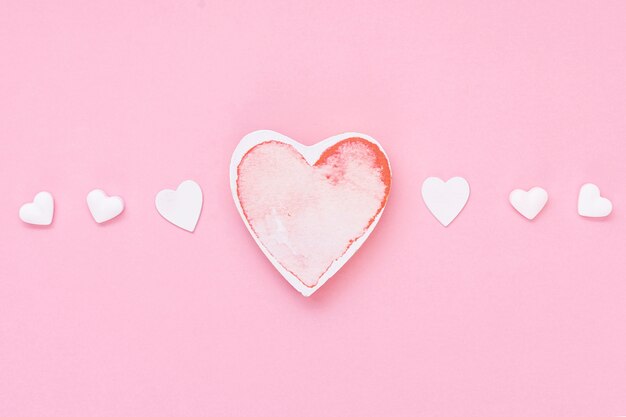 Disposizione vista dall'alto con biscotti a forma di cuore e sfondo rosa