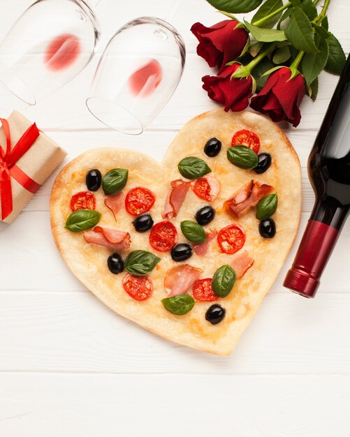 Disposizione vista dall'alto con pizza a forma di cuore