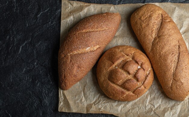 Diverse pagnotte di pane su sfondo nero.