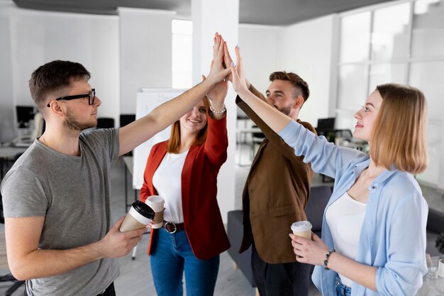 Diverse persone si danno il cinque al lavoro