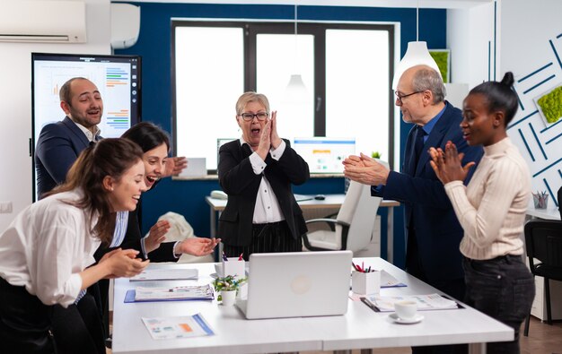 Diverse squadre esecutive aziendali che applaudono nella sala conferenze