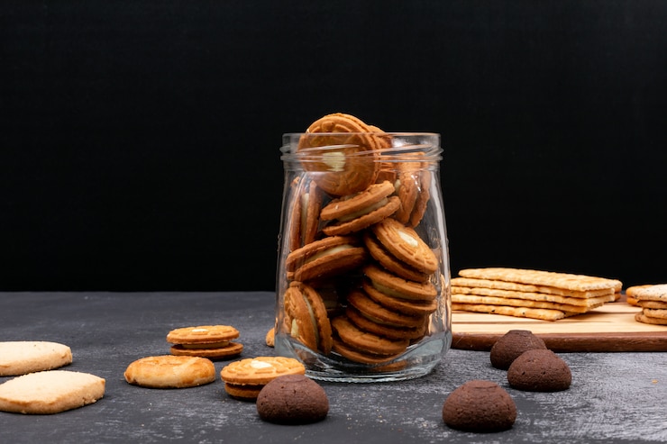 Foto gratuito diversi biscotti in barattolo di vetro su superficie scura