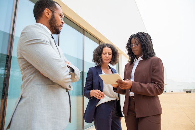 Diversi colleghi di lavoro con tavoletta digitale discutendo il progetto