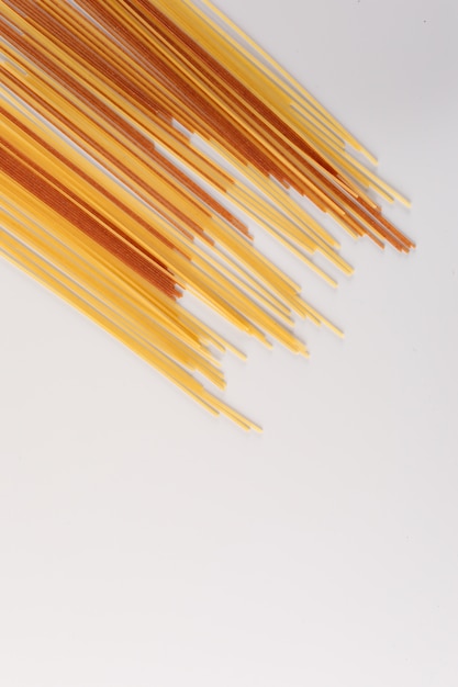 diversi spaghetti crudi con copia spazio sulla superficie bianca