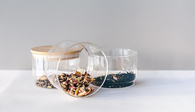 Diversi tipi di tè in vasetti di vetro su uno sfondo chiaro isolato
