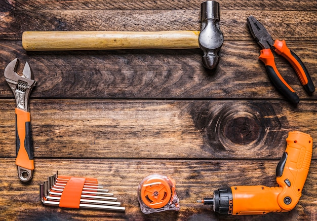 Diversi tipi di utensili da lavoro su fondo in legno