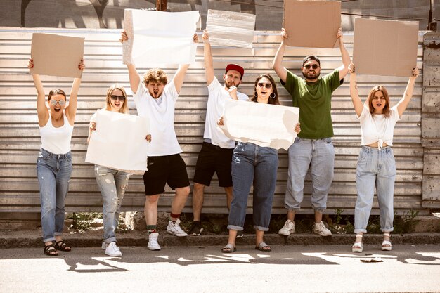 Diverso gruppo di persone che protestano con segni vuoti. Protesta contro i diritti umani, abuso di libertà, questioni sociali