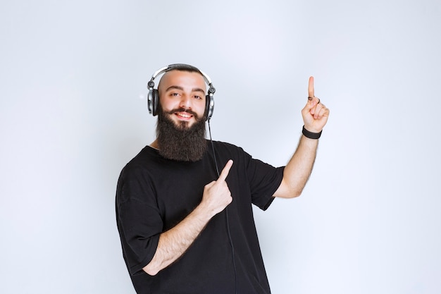 DJ con la barba che indossa le cuffie e si presenta.