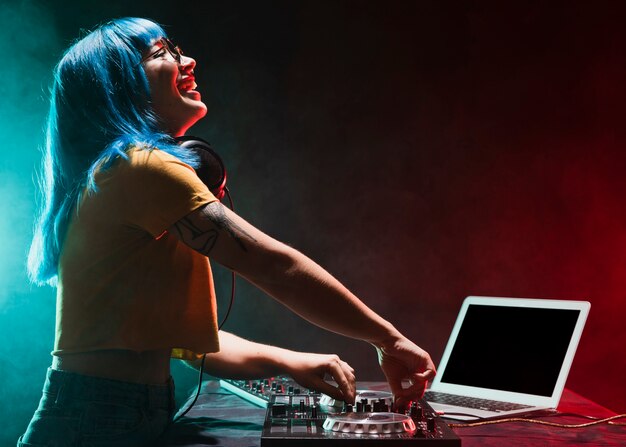 DJ femminile di vista frontale che controlla la console audio