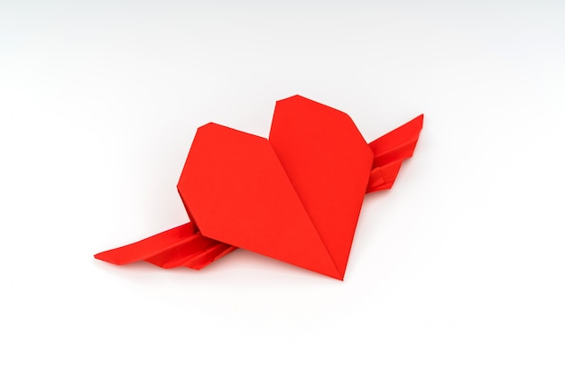 Documento rosso cuore origami con le ali su sfondo bianco.