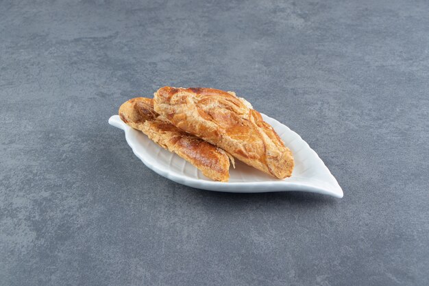 Dolci a forma di triangolo ripieni di formaggio sul piatto bianco.